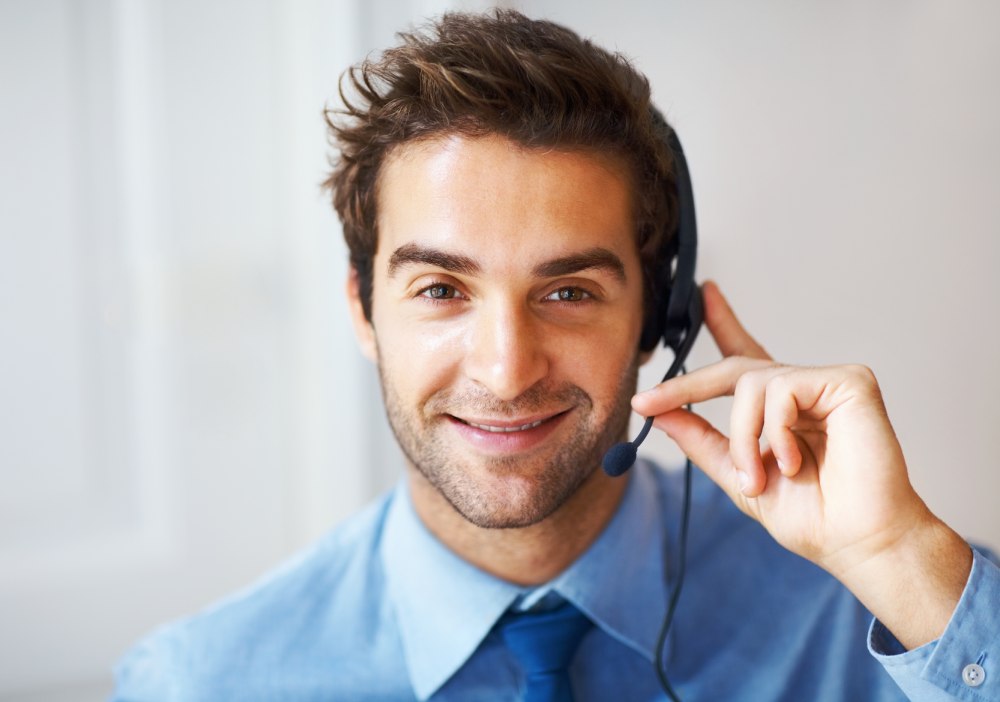 A man smiling while wearing a headset.